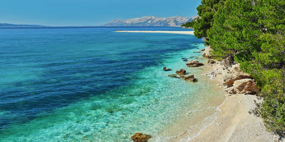 Strand mit Felsen und türkisblauem Meer Kroatien